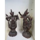 A pair of early to mid 20th century Burmese carved wooden figures in traditional dance costumes,