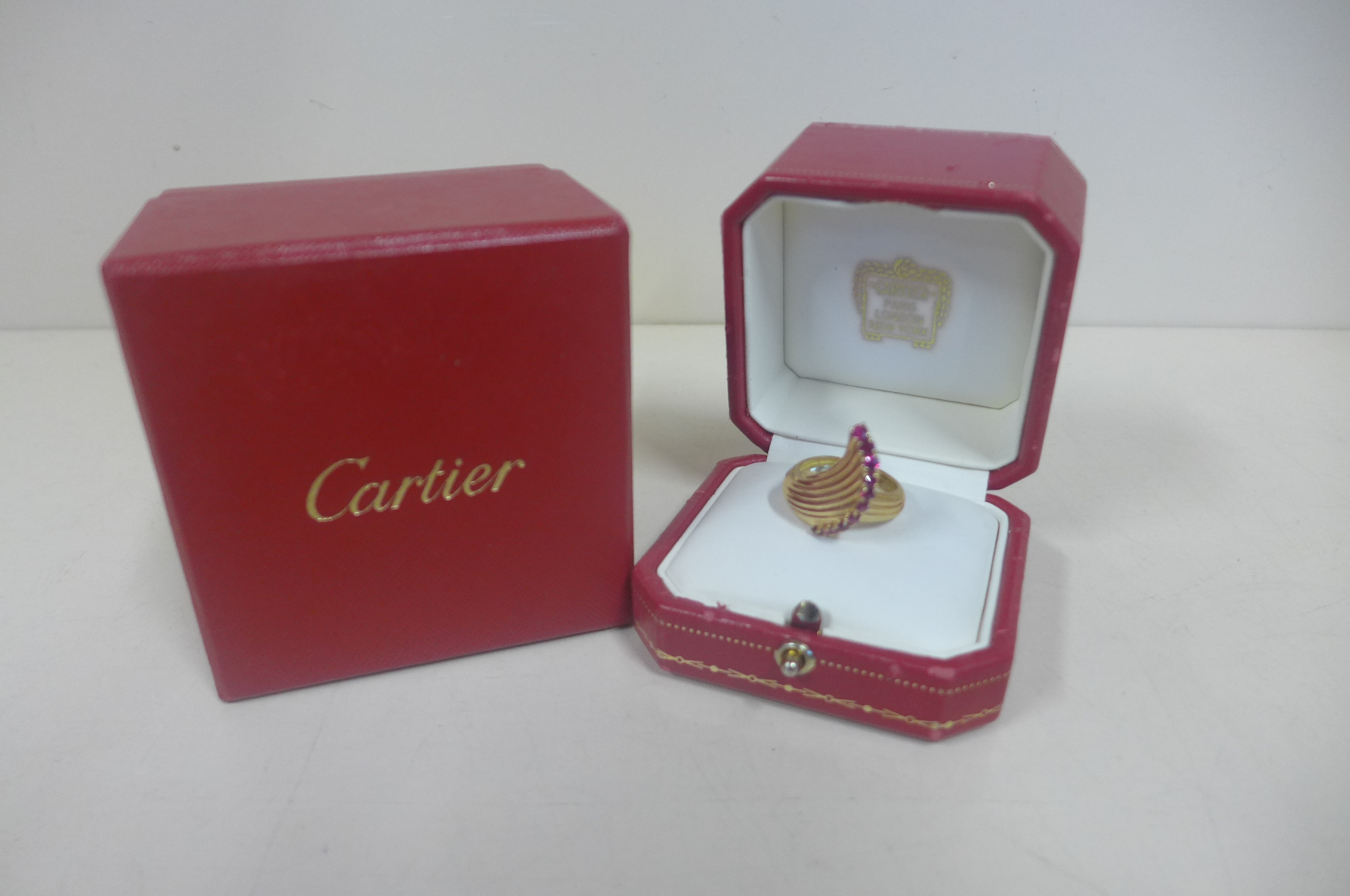 An 18ct yellow gold Cartier ring, fluted swept design set with Cartier signature, with ring box