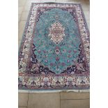 A hand knotted woollen Ladik rug with a teal coloured field, 307cm x 195cm - some small usage