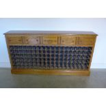 An oak 108 bottle wine rack with five wine box front drawers, made by a local craftsman
