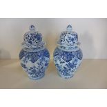A pair of Delft lidded vases, marked AR, 18cm tall , small chips to both, knop repaired to one and