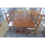 A good quality clover oak refectory table with six ladder back rush seated chairs, 76cm tall x 221cm