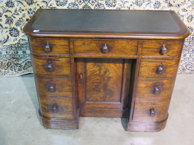 A 19th century mahogany bow fronted kneehole desk, with a lift up top above six drawers and a