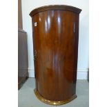 An early 19th century mahogany bow fronted corner cupboard of small proportions, 65cm tall, 38cm