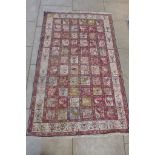 A hand knotted woollen rug, decorated with birds and geometric designs, 204cm x 125cm