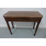 A 19th century mahogany fold over tea table on turned legs, 69cm W