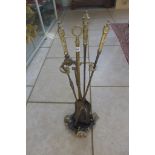 A set of three steel and brass early 19th century fire irons with later French decorated stand