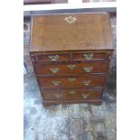 A mahogany bureau of small proportions with a fitted interior above two small and three long