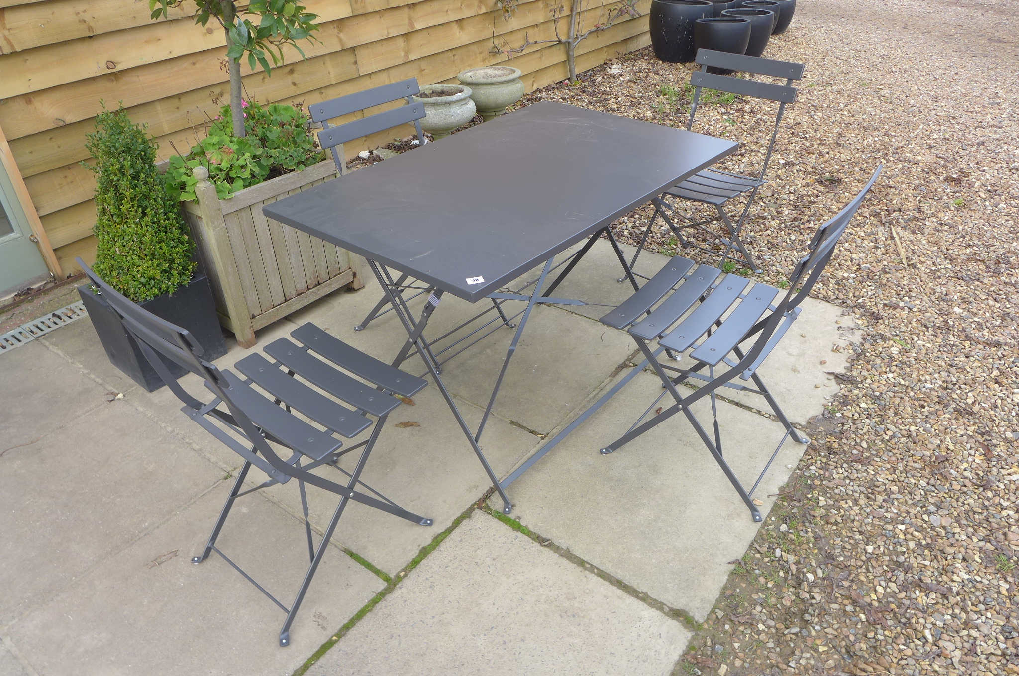 A metal folding garden table and four chairs in grey, ex-John Lewis