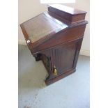 A Victorian mahogany Davenport desk with a side cupboard enclosing four drawers, one stamped