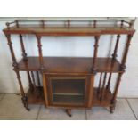 A Victorian walnut three tier side cabinet with a single glazed door and turned supports, 109cm tall