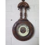 A late Victorian walnut aneroid barometer with carved surround, height 38cm, width 18cm, clean but