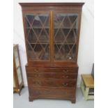 A 19th century secretaire chest with an associated astragel glazed top over a fitted secretaire