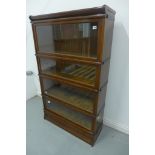 An oak Globe Wernicke four section stacking bookcase, with a base drawer 146cm tall, 86cm wide, 31cm