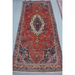 A hand knotted woollen Hamadan rug - 303cm x 141cm