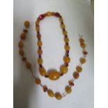 A quantity of oval and facet cut amber beads, require re stringing, egg yolk and clear beads, weight