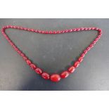 A graduated string of cherry amber oval beads, the largest 30mm x 8mm, length of string 79cm, weight