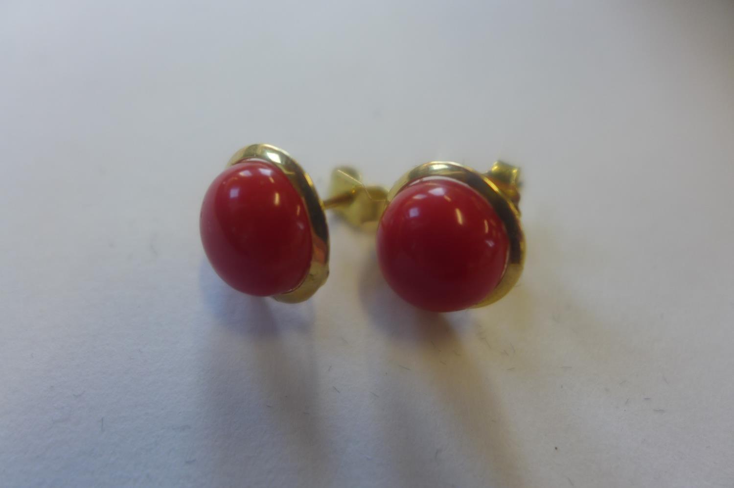 A pair of 18ct coral set earrings, marked 750, approx 2.9 grams, 10mm diameter, generally good