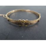 A Victorian style 9ct rose gold diamond set hinged bangle with three small diamonds, weight approx