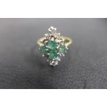 An 18ct gold emerald and white stone ring, possibly white sapphires, not hallmarked but tested as