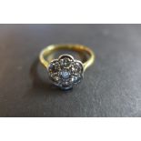 An 18ct gold and platinum diamond daisy cluster ring, set with six diamonds around a central diamond