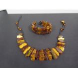 A Baltic amber necklace and bracelet of slab cut polished amber, largest piece 27x12mm, total weight