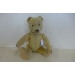 A 1950's bear, probably Steiff, 30cm tall, no button, golden mohair with some wear, old repairs to