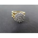 An 18ct gold and diamond cluster ring on pierced shank set with nineteen small round cut diamonds,