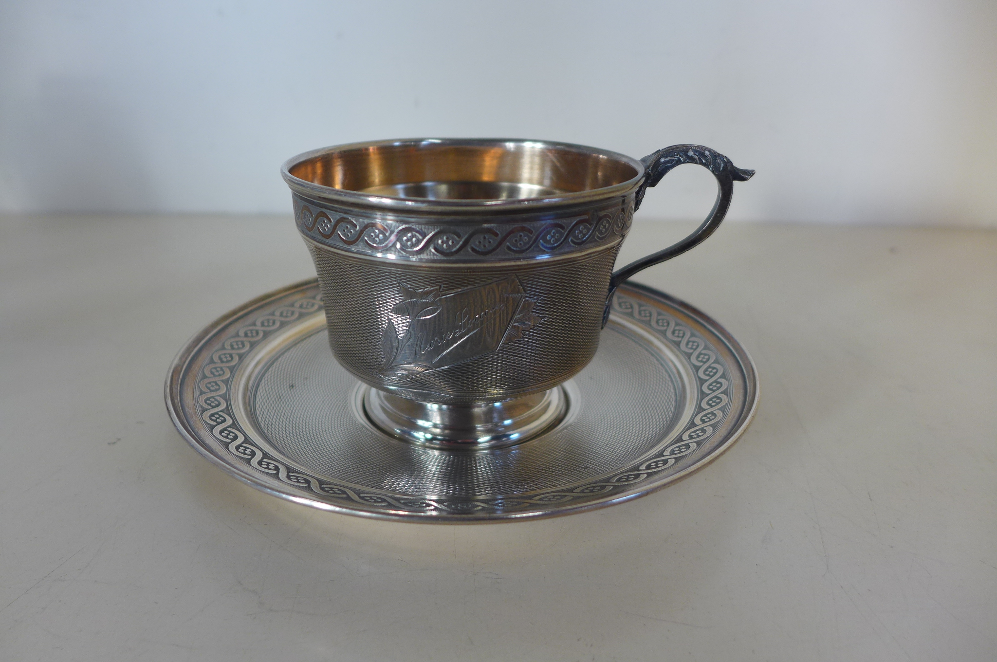 A continental silver cup and saucer, saucer 15cm diameter, engraving to cup, approx 6.2 troy oz,