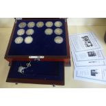 A collection of twelve Barber silver half dollars with corresponding date cards, in a mahogany