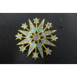 A good quality 18ct gold and opal star brooch, set with 33 cabachon polished opals, not hallmarked
