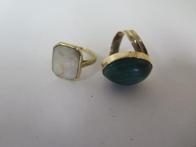 A yellow metal dress ring, grooved, offset shank to an oval cabochon of malachite, 19.5mm x 14.