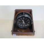 A US Army key wind bulkhead clock message centre M2 in a wooden case, 19cm diameter, over wound in