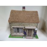 A 12th scale dolls house room box, 'Rose Cottage' thatched roof, fully furnished and lit by