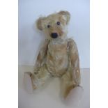 An early 1900's bear, 42cm tall, possibly replaced boot button eyes, restored nose and pads,