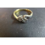 An 18ct gold and platinum diamond crossover ring set with two diamonds, approx 0.1cts each, in a