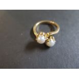 A 9ct gold and pearl crossover ring, set with two pearls each, approx 5mm diameter, ring size M -