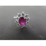 An 18ct white gold ruby and diamond ring set with a central ruby measuring approx 9mm by 6mm,