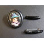 A jet oval brooch with porcelain plaque centre containing transfer printed and coloured portrait
