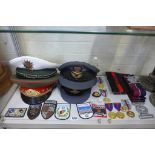 A collection of RAF Police peaked caps, stable belts and commemorative medals, together with