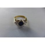 An 18ct yellow gold and platinum sapphire and diamond ring, each diamond approx 0.25ct, central