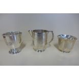 Two engraved silver tankards and an engraved silver milk jug, dents and wear to jug and smaller