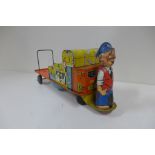 A Mettoy tin plate clockwork BR Railway platform luggage trolley with driver - 30cm long, in running