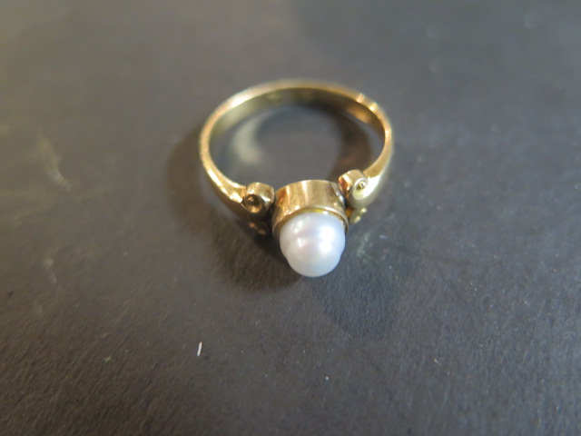 An 18ct gold ring set with a single baroque pearl in a collett setting, pearl approx 6mm in