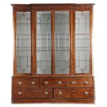 A Regency mahogany breakfront bookcase, inlaid with ebonised decoration, the detachable moulded