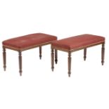 A pair of 19th century mahogany stools, each with a stuffed-over studded seat, on turned and