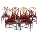 A set of eight George III mahogany dining chairs, each with a serpentine top rail, above a pierced