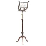 A mahogany and brass music stand in Regency style, the lyre rest on an adjustable brass stem, on