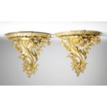 A pair of gilt bronze Rococo style wall brackets, each with a breakfront top above a leaf edge and a