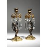 A pair of 19th century gilt and patinated bronze figural lustre candlesticks, each with a Bacchic